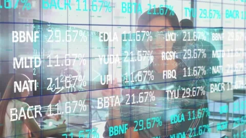 Four professionals reviewing finance data at table, projecting data grid showing Stock Footage 327008937