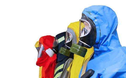 Four protective suits in different colors stand side by side for use in hazar Stock Photos