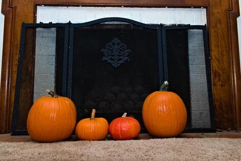 Four Pumpkins in Front of a Fireplace Stock Photos