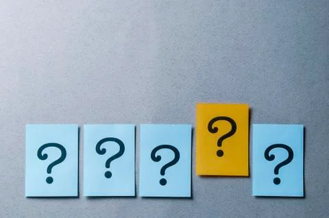 Four question marks on blue and one on yellow Stock Photos