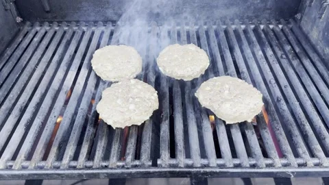 Four Raw Meat Patties Being Grilled on a BBQ 動画素材 341067803
