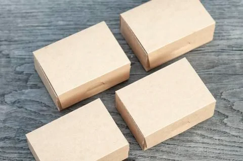 Four rectangular boxes on a wooden board. Mockup of a cardboard package. Stock Photos