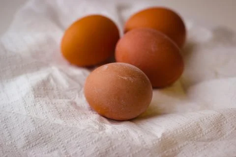 Four red chicken eggs on a white paper napkin Stock Photos
