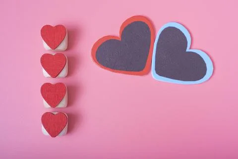 Four red hearts vertically in a row on the left side, pink background. Stock Photos