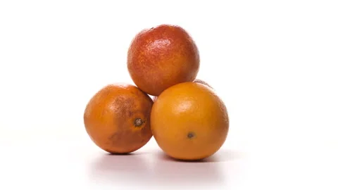 Four red oranges are spinning on white background. Freshly picked fruits on Stock Footage 148508207