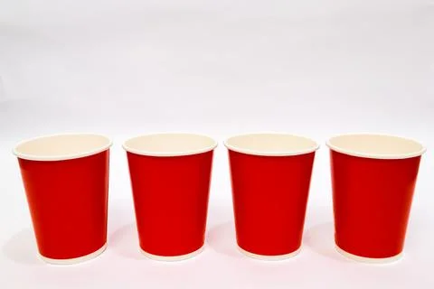 Four red paper cups lined up on a white surface, ready for beverages and ev.. Stock Photos