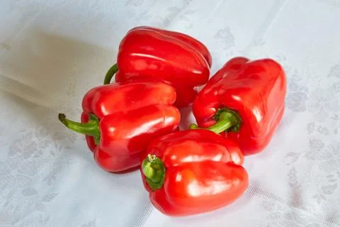 Four red pepper lie on a table Stock Photos
