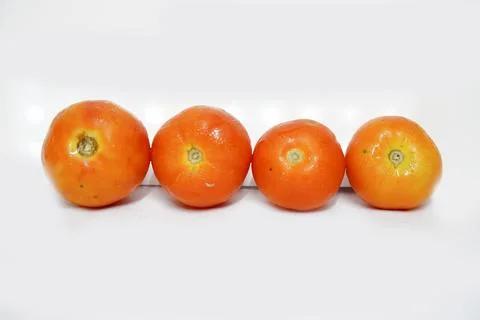 Four Red tomatoes are lined up shown isolated on a white background Foto stock