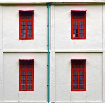 Four red windows on a white stone wall Stock Photos
