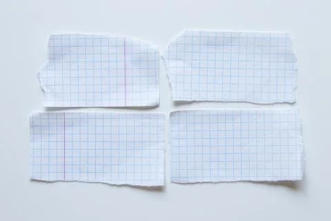 Four ripped rectangular pieces of white paper in a blue grid and laid out o.. Stockfoto's