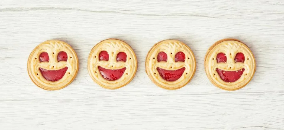 Four round biscuits smiling faces Stock Photos