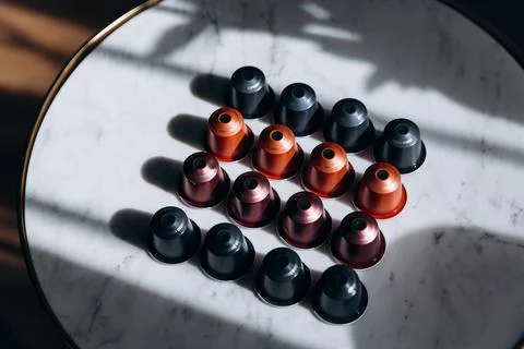 Four rows of coffee capsules with shadow on table Stock Photos