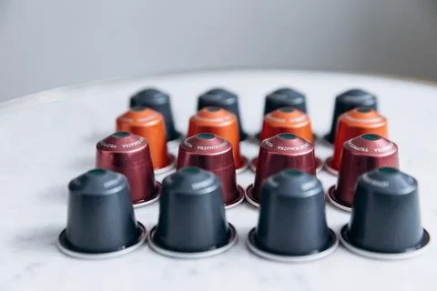 Four rows of coffee capsules on white background Stock Photos