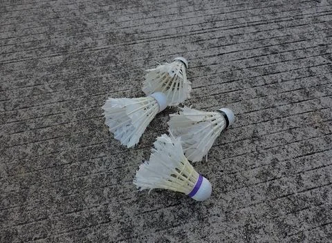 Four Shuttlecocks on Rough Concrete Surface Stock Photos