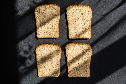 Four slices of bread in the form of toasts lie on a black tablecloth Stock Photos