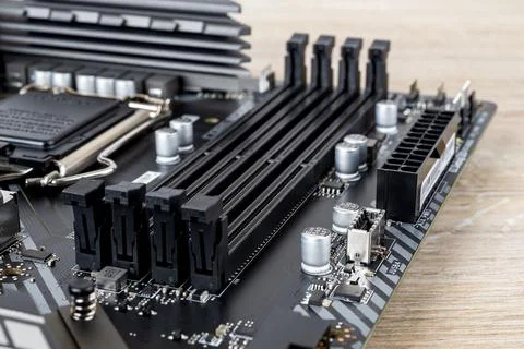 Four slots for ddr4 ram memory modules on a modern black pc motherboard. Comp Stock Photos
