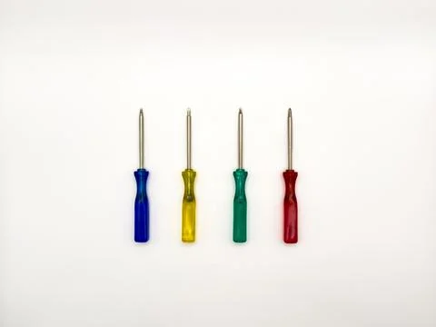 Four small colored plastic screwdrivers on a white background. copy space, flay Stock Photos