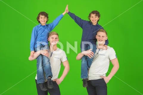 The four smile brothers stand on the green background Stock Photos