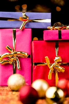 Four solid gift boxes and festive spheres . Stock Photos