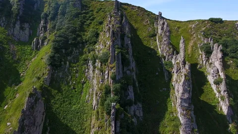 Four spiky rows of rocks on a stepp slope of a Carpathian mountain in summer Stock Footage 88524977