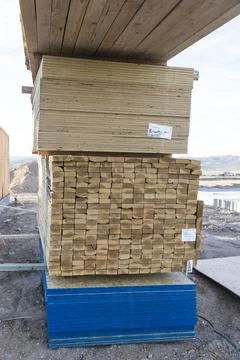 Four stacks of different sized lumber waiting to be used at a construction si Stock Photos