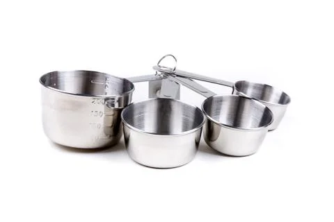 Four stainless steel measuring cups clipped together over white Stock Photos