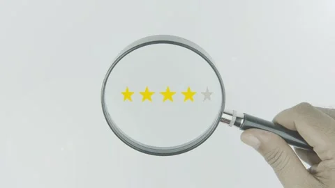 Four Star Review text or word highlighted by a magnifying glass in a hand Stock Footage 303628046
