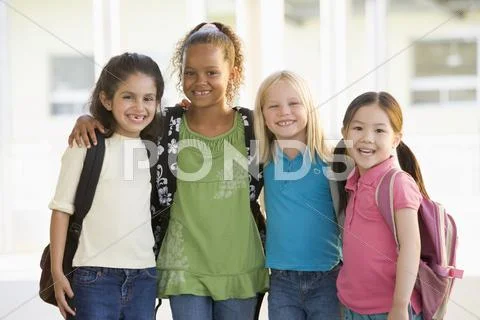 Four students outside school standing together smiling (high key) Stock Photos