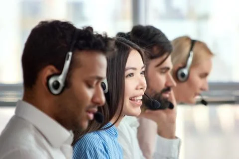 Four support phone operators at workplace. Stock Photos
