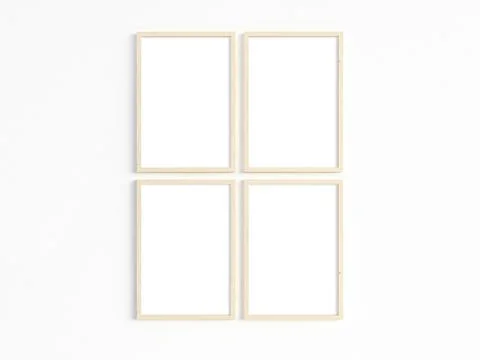 Four thin A4 wooden frames with portrait orientation on a light wall. Stock Photos