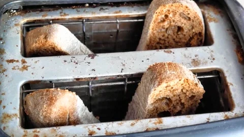 Four toasted slices of bread pop out of an old toaster Stock Footage 328279613