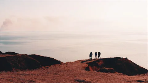 The four tourists with backpack walking in the mountains on the seascape Video stock 156642727