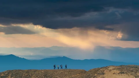 The four tourists walking on the mountain range on the rainy sky background Video stock 141031351