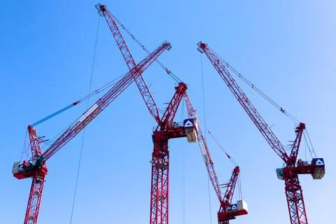 Four towering cranes work at Berlin construction site Stock Photos