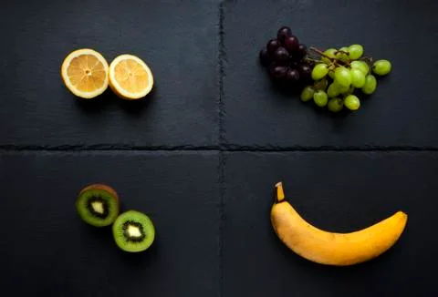 Four types of fruit on slate table Stock Photos