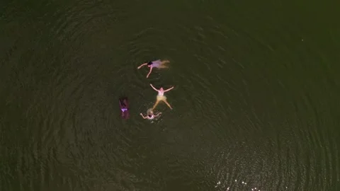 Four unrecognizable girls swim in the lake Stockbeeldmateriaal 221420249