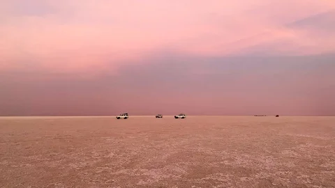 Four wheel drives going along the barren land on sunrise tc01 Stock Footage 102224459