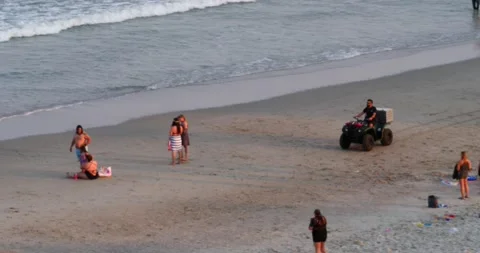 Four-wheeler riding Myrtle Beach during hot summer day lifeguard crowded beach Stock Footage 234593448