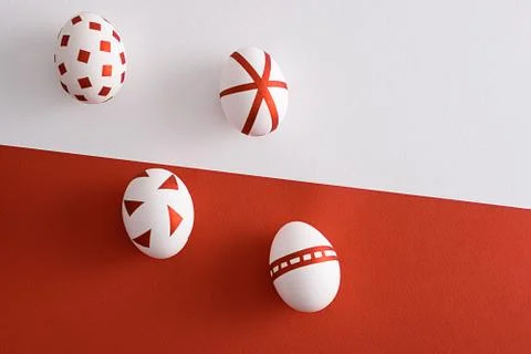 Four white Easter eggs with red geometric pattern on red and white background Stock Photos