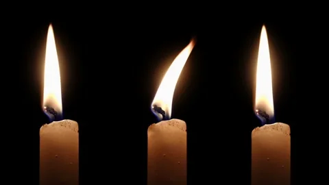 Four White Taper Candles Burning at Different Heights on Black background Stock Footage 335884111