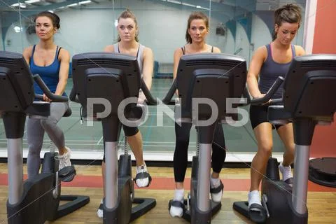 Four women working out at spinning class Stock Photos