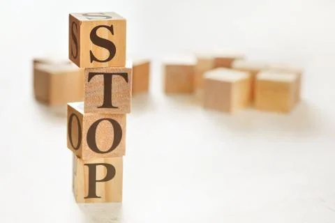 Four wooden cubes arranged in stack with word STOP on them, space for text image Stock Photos