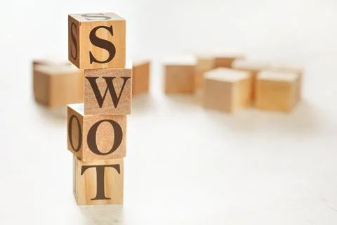 Four wooden cubes arranged in stack with text SWOT (meaning Strengths, Weakne Stockfoto's