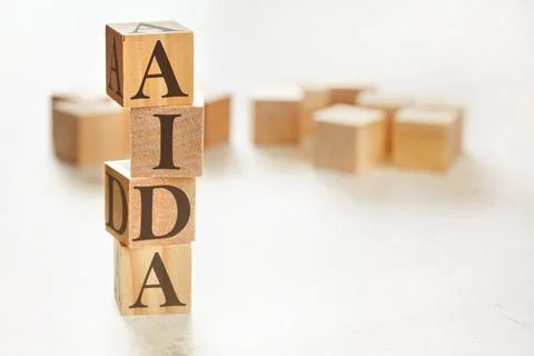 Four wooden cubes arranged in stack with letters AIDA (meaning Awareness Inte Stock Photos