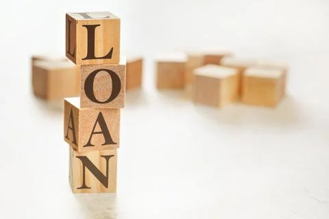 Four wooden cubes arranged in stack with word LOAN on them, space for text /  Stock Photos