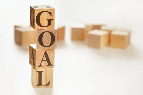 Four wooden cubes arranged in stack with word GOAL on them, space for text /  Stock Photos