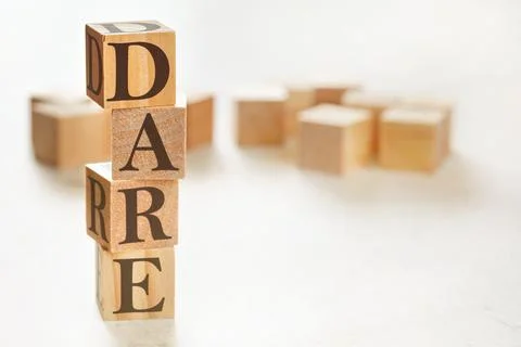 Four wooden cubes arranged in stack with text DARE (meaning Define, Assess, R Stock Photos