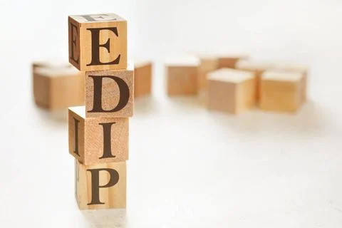 Four wooden cubes arranged in stack with letters EDIP meaning Explain, dem... Stockfoto's