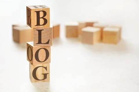 Four wooden cubes arranged in stack with word BLOG on them, space for text... Stockfoto's