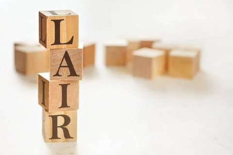 Four wooden cubes arranged in stack with text LAIR (meaning Listen, Acknow... Stockfoto's